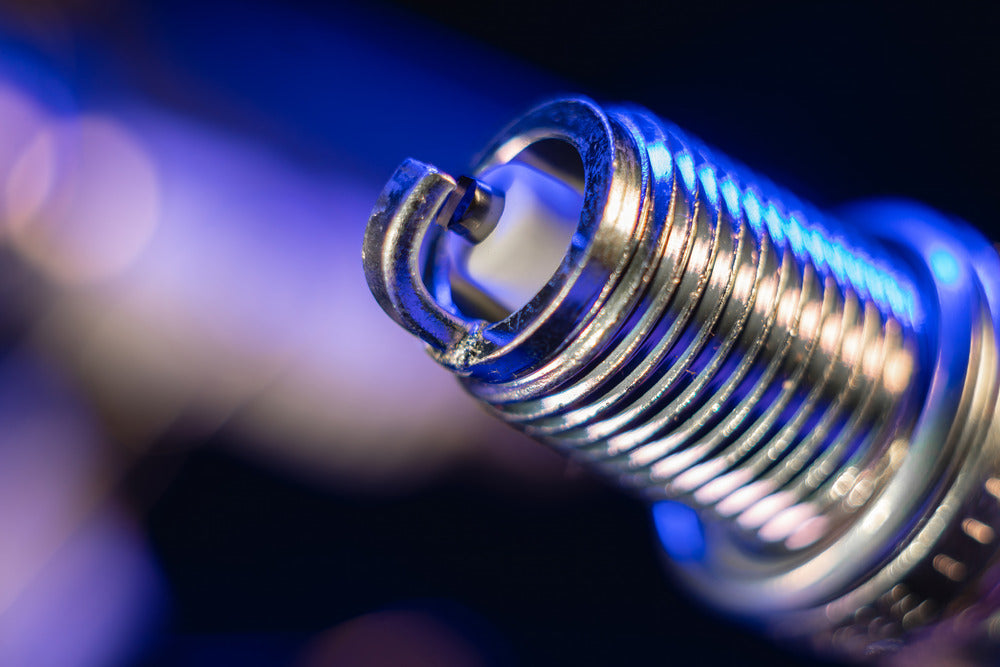 A close-up view of a brand-new nickel electrode spark plug for an automotive internal combustion engine.