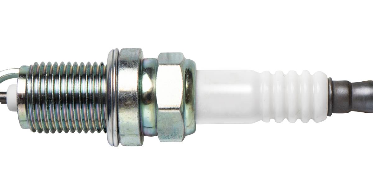 A side profile of a new automotive spark plug. The plug is displayed horizontally and isolated against white.